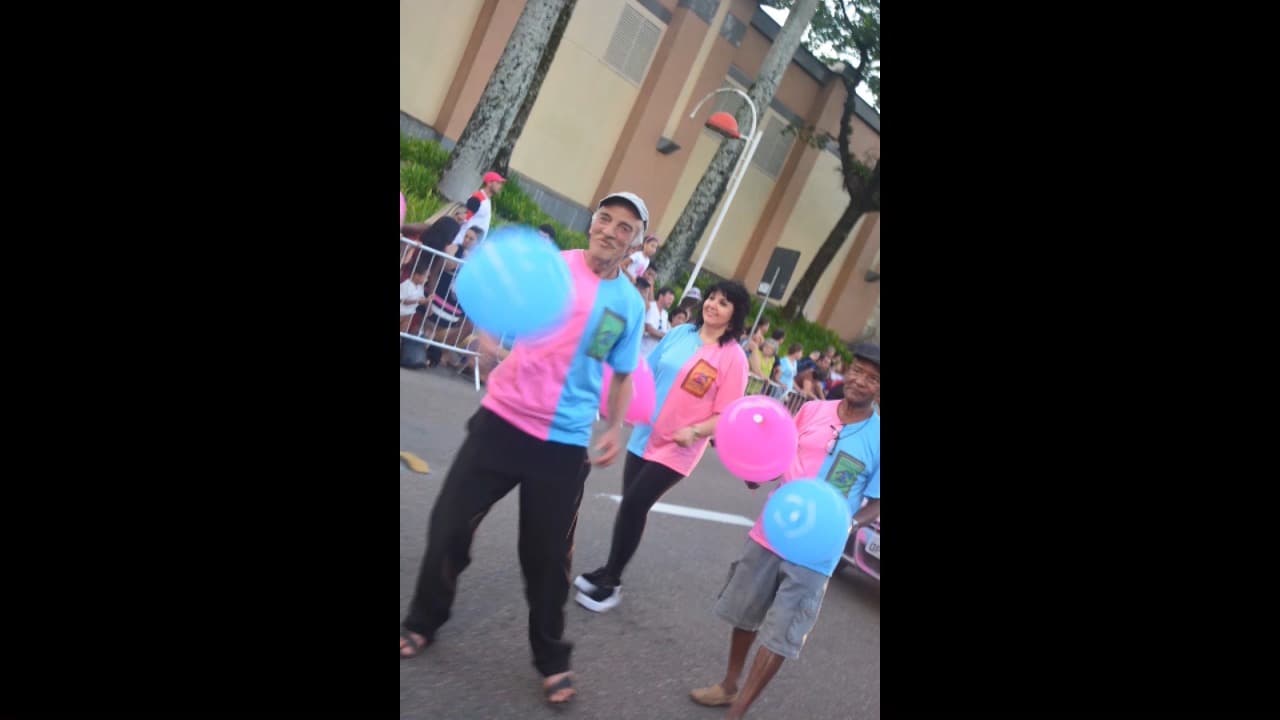 Voluntários sorrindo com balões no desfile dos 169 anos de Joinville