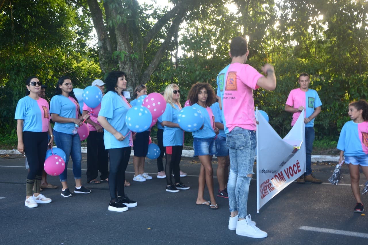 Voluntários e pacientes caminhando juntos no desfile aniversário de Joinville